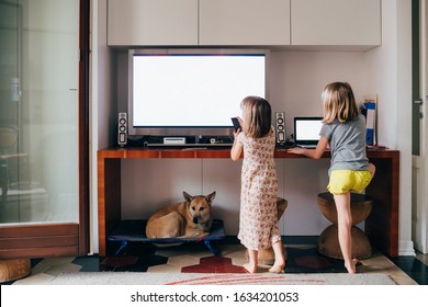 Two Female Children Watching Too Close Television And Computer - Entertainment, Screen Time, Baby Sitter Concept