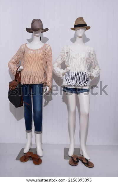 Two female in\
clothes and jeans ,shorts, on a full dummy with hat and\
shoes,handbag  isolated gray\
background
