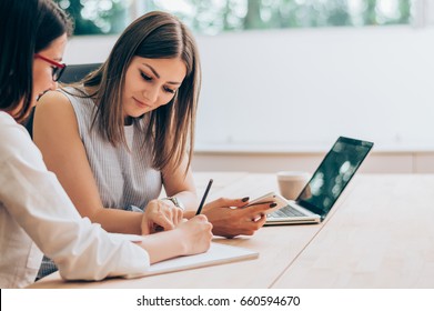 Two female colleagues in office working together.