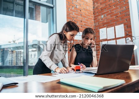 Two female colleagues in office working together.