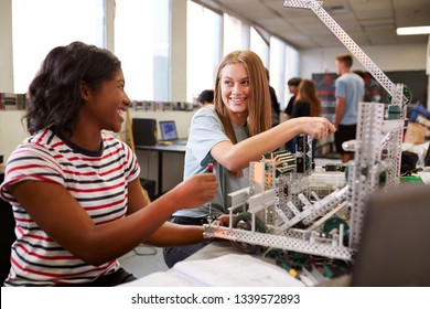 Two Female College Students Building Machine In Science Robotics Or Engineering Class