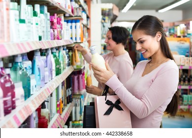Two Female Customers Selecting Haircare Products In Drugstore. Selective Focus 

