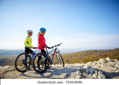 Two Female Cyclist Woman Enjoying The Beautiful Scenery While Out Mountain Biking.