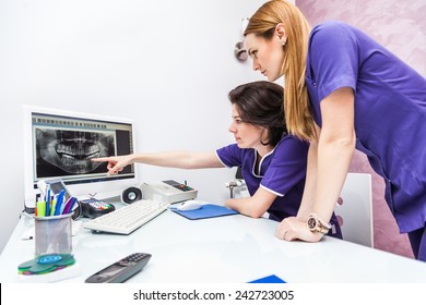 Two Female Dentist Looking At X-ray Image On Computer Screen