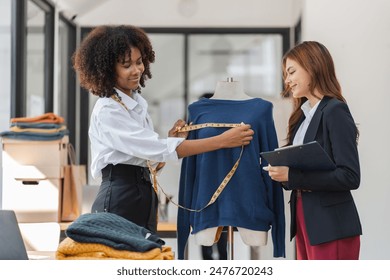 Two Female Designers Collaborating on Shirt Design in Modern Studio with Measuring Tape and Mannequin - Powered by Shutterstock