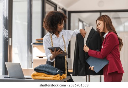 Two Female Designers Collaborating on Shirt Designs in a Modern Studio Setting - Powered by Shutterstock