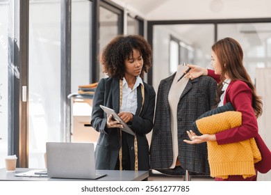 Two Female Designers Collaborating on Shirt Designs in a Modern Studio Setting - Powered by Shutterstock