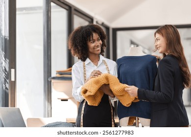 Two Female Designers Collaborating on Shirt Designs in a Modern Studio Environment - Powered by Shutterstock