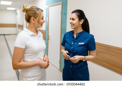 Two Female Doctors Talking In Clinic Hall, Surgery And Stomatology. Medical Workers In Uniform, Medicine And Health, Professional Healthcare In Hospital