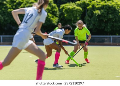 Two female field hockey players fighting for the ball on the pitch. - Powered by Shutterstock