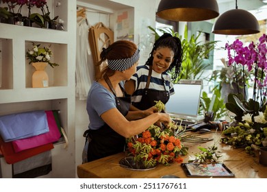 Two female florists arranging flowers in a shop - Powered by Shutterstock