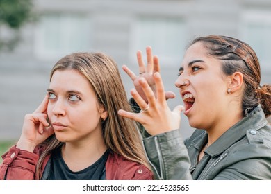 Two Female Friends Arguing In The Street Outdoors