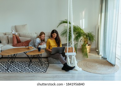 Two Female Friends Chilling At Home At Using Technology