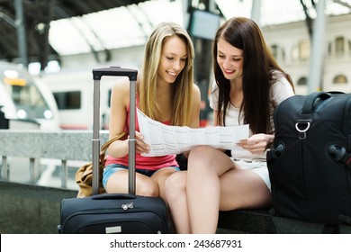 Two Female Friends With City Map And Luggage At Railway Station