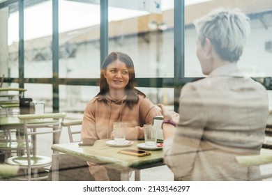 Two Female Friends Drinking Coffee And Enjoying Time In The Cafe At Railway Station