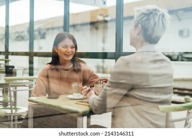 Two Female Friends Drinking Coffee And Enjoying Time In The Cafe At Railway Station