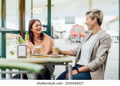 Two Female Friends Drinking Coffee And Enjoying Time In The Cafe At Railway Station