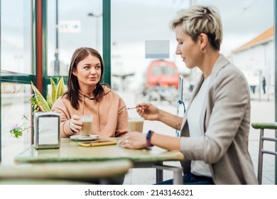 Two Female Friends Drinking Coffee And Enjoying Time In The Cafe At Railway Station