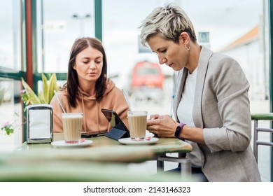 Two Female Friends Drinking Coffee And Enjoying Time In The Cafe At Railway Station