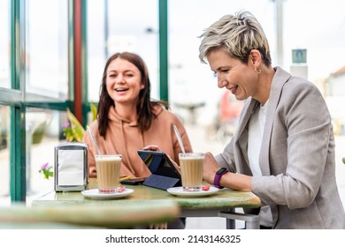 Two Female Friends Drinking Coffee And Enjoying Time In The Cafe At Railway Station