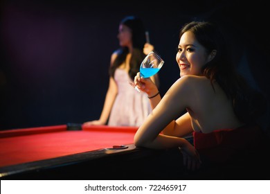 Two Female Friends Drinking Wine Alcohol And Playing Billiard Game In Restaurant. Concept Of Night Party, Celebration, Happy New Year And Lady Night.