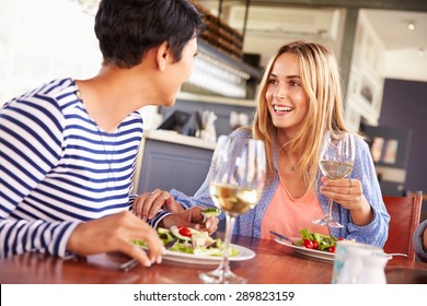 Two Female Friends Eating At A Restaurant