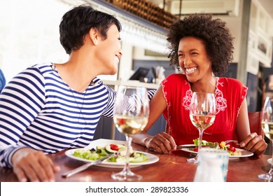 Two Female Friends Eating At A Restaurant