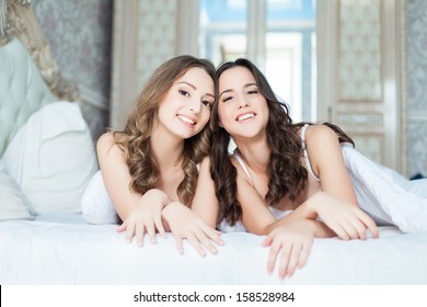 Two Female Friends In Lingerie On The Bed