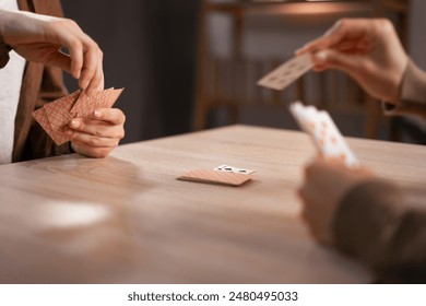 two female friends playing card game at home spend happy time together. Close-up - Powered by Shutterstock