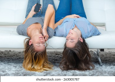 Two Female Friends Sharing Headphones