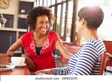 Two female friends talking at a coffee shop - Shutterstock ID 289831070