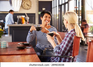 Two Female Friends Talking At A Coffee Shop