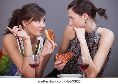 Two Female Friends Talking In Studio With Glasses Sparkling Wine And Pizzas