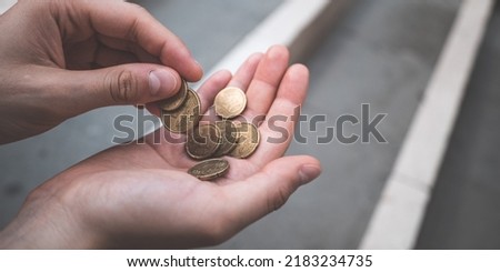 Two female hands holding and counting euro coins on the street