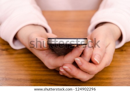 Two female hands are holding a smart phone