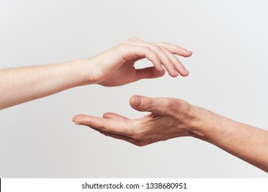 Two female hands stretch each other gray background