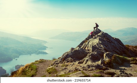 Two female hikers on top of the mountain enjoying valley view, Ben A'an, Loch Katrina, Highlands, Scotland, UK