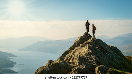 Two female hikers on top of the mountain enjoying valley view, Ben A'an, Loch Katrine, Highlands, Scotland, UK