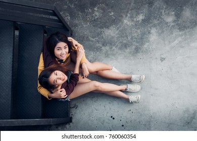 Two Female Lesbian Lgbt Couple Sitting At Black Rooftop Stair  Hug Together And Looking Up At Party,love Wins Concept,top View