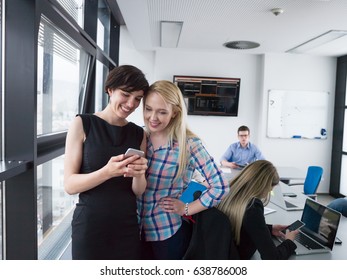 two female managers using cell telephone in office interior