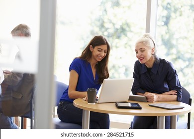 Two Female Mature Students Working Together Using Laptop