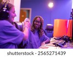 Two female pro gamers are shaking hands after an esports competition, celebrating their teamwork and sportsmanship in a vibrant gaming room filled with colorful lights and computer setups