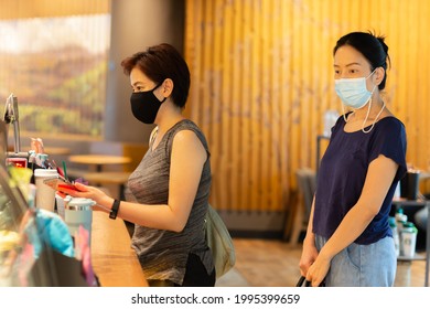 Two Female In Protective Mask Buying Coffee From Coffee Shop