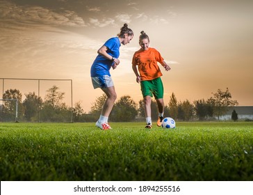 Two female soccer players on the field in sunset - Powered by Shutterstock