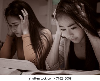 Two Female student reading a book for the exam or doing homework.young asian college student at hard exam. - Shutterstock ID 776248009