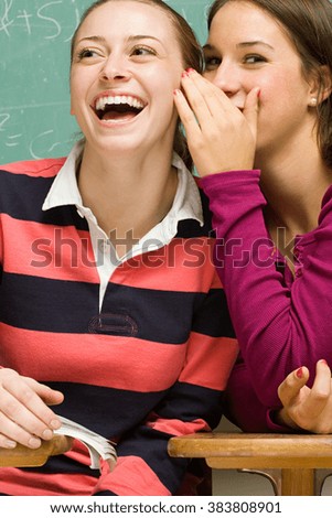 Two female students sharing a secret