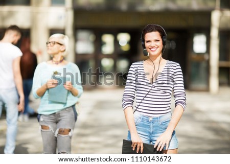 Two female students standing in front of a university 