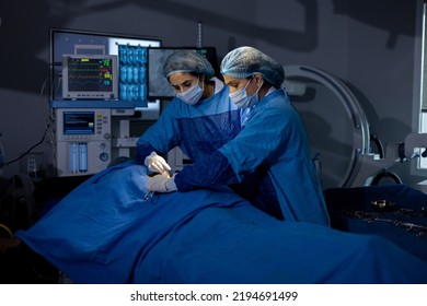 Two female surgeons performing surgery at hospital operating room - Powered by Shutterstock