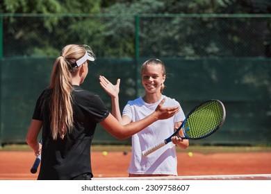 Two female tennis players shaking hands with smiles on a sunny day, exuding sportsmanship and friendship after a competitive match. - Powered by Shutterstock