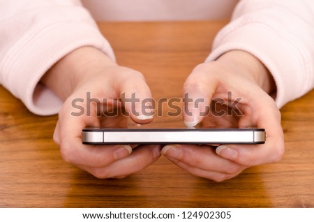 Two female thumbs are typing on a smart phone